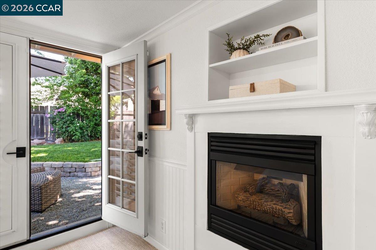 4175 Pickwick Drive Concord, CA 94521 - Photo 27 of 41 a living room with a fireplace and a floor to ceiling window