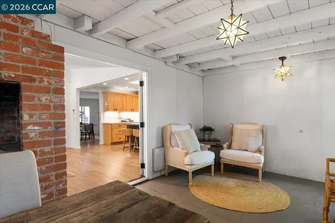 a living room with furniture a dining table and a chandelier