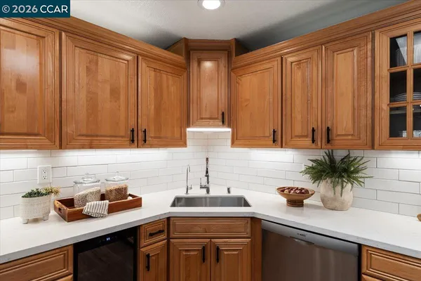 a kitchen with stainless steel appliances a sink a potted plant and cabinets