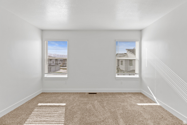 1262 West 500 South Logan, UT 84321 - Photo 35 of 39 Room featuring neutral-toned carpet, white walls, and two windows with blinds