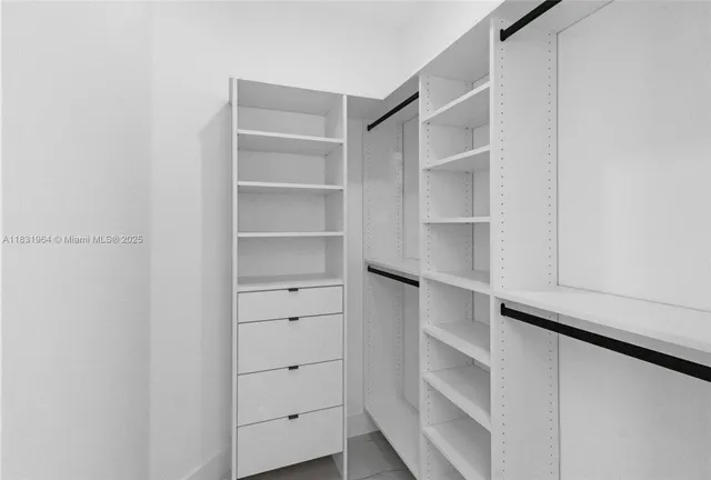 a view of walk in closet with empty racks