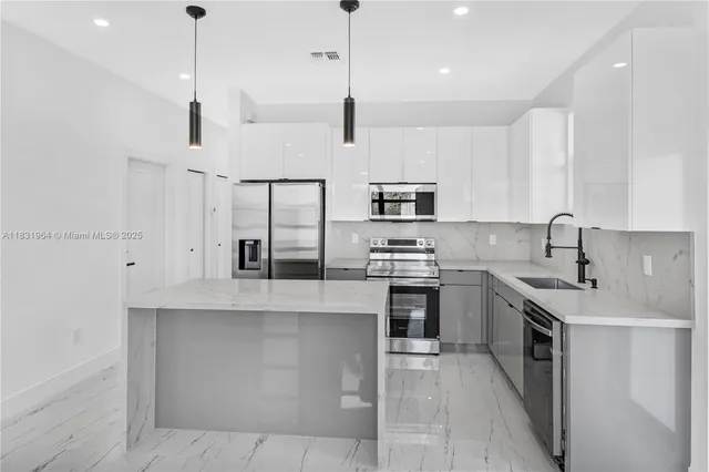 a kitchen with stainless steel appliances granite countertop a sink a stove and a refrigerator