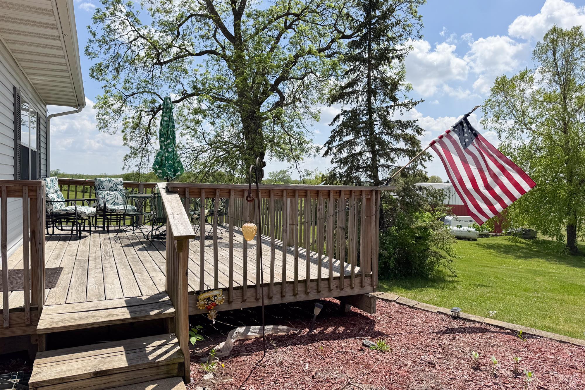 15767 Crowley Road Durand, IL 61024 - Photo 8 of 18 a view of a wooden deck with chairs and a yard