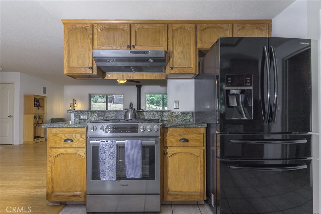 45315 Forest Ridge Drive Ahwahnee, CA 93601 - Photo 11 of 75 a kitchen with stainless steel appliances granite countertop a refrigerator and a stove