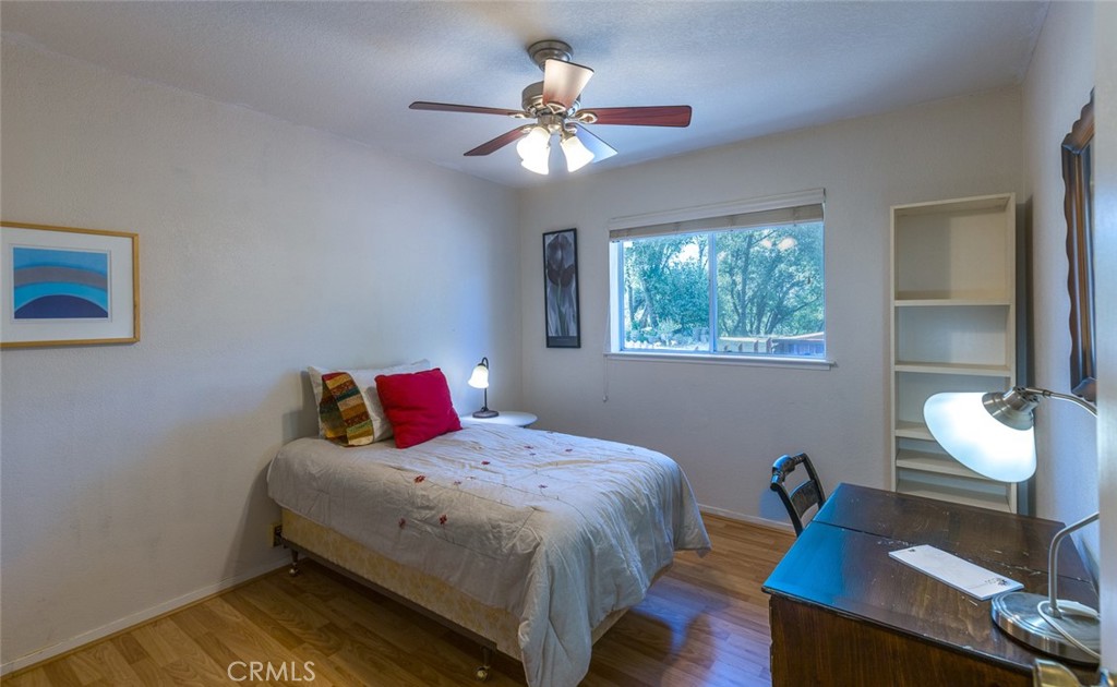 45315 Forest Ridge Drive Ahwahnee, CA 93601 - Photo 21 of 75 a bedroom with a bed and a chandelier