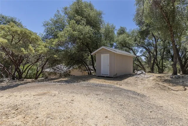 a view of a house with a yard patio and tree