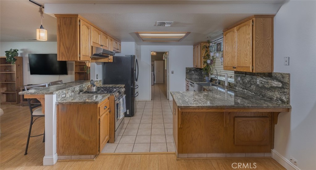 45315 Forest Ridge Drive Ahwahnee, CA 93601 - Photo 9 of 75 a kitchen with stainless steel appliances granite countertop a sink stove and refrigerator