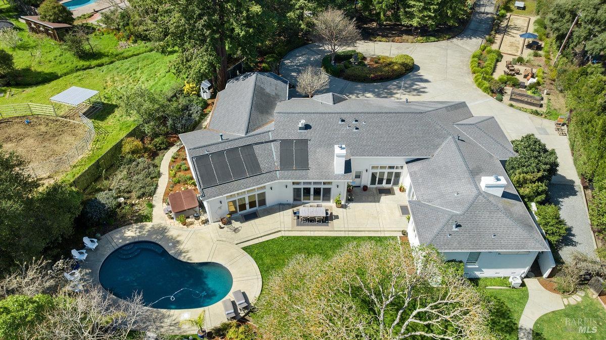 an aerial view of a house with swimming pool and garden