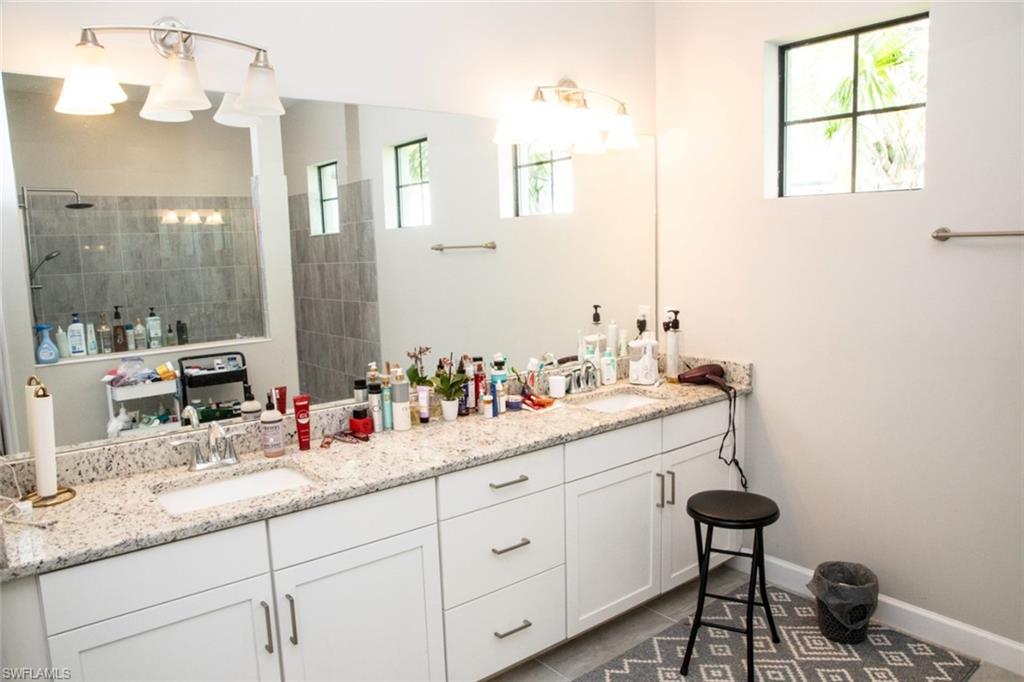 11726 Canopy Loop Fort Myers, FL 33913 - Photo 19 of 40 Bathroom with double vanity, walk in shower, and dark tile patterned floors