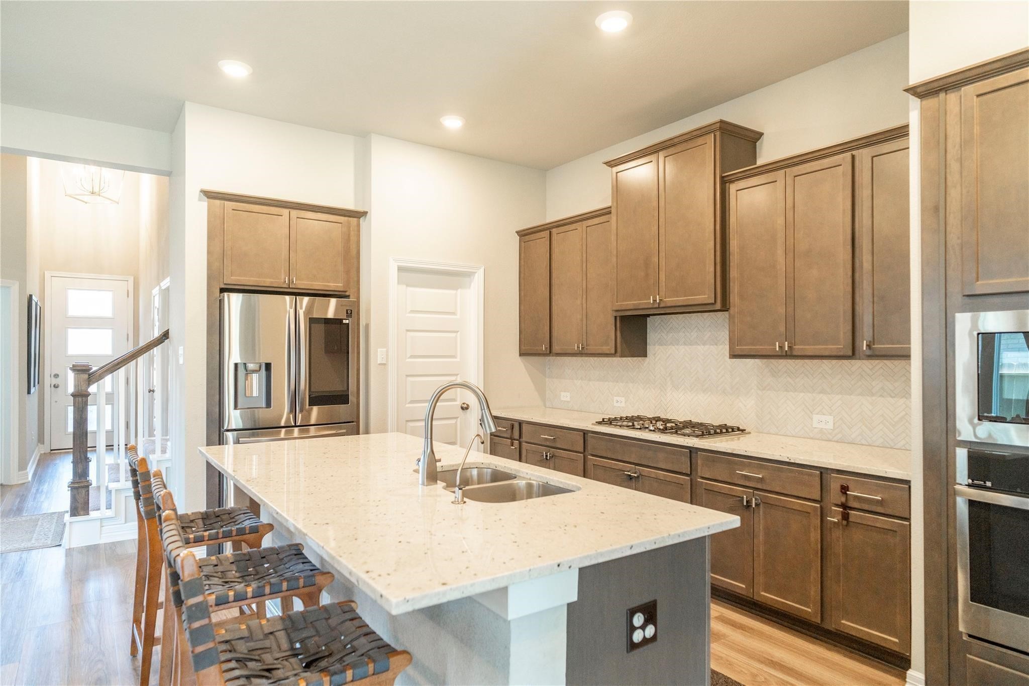 29023 Laurel Grove Lane Fulshear, TX 77441 - Photo 14 of 42 a kitchen with a sink refrigerator and cabinets