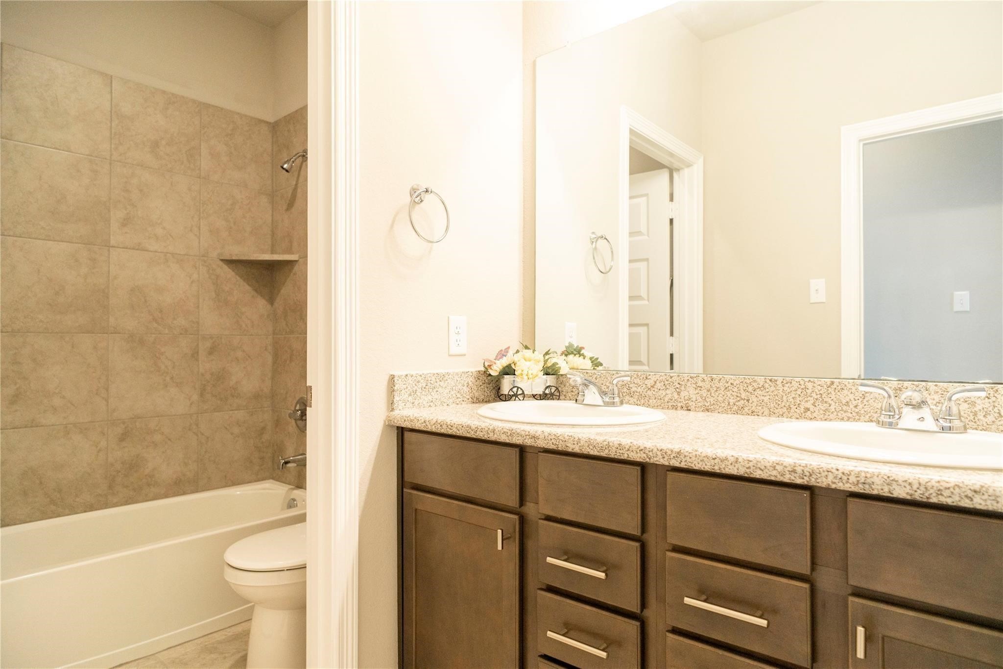 29023 Laurel Grove Lane Fulshear, TX 77441 - Photo 34 of 42 a bathroom with a granite countertop sink toilet and shower