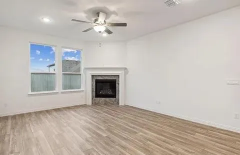 a view of an empty room with a window and fireplace