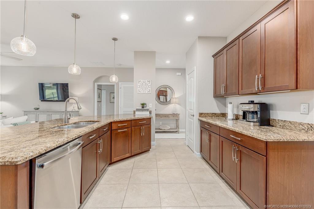 2185 Northwest Dalea Way Stuart, FL 34994 - Photo 15 of 55 a large kitchen with stainless steel appliances granite countertop a sink and a white cabinets