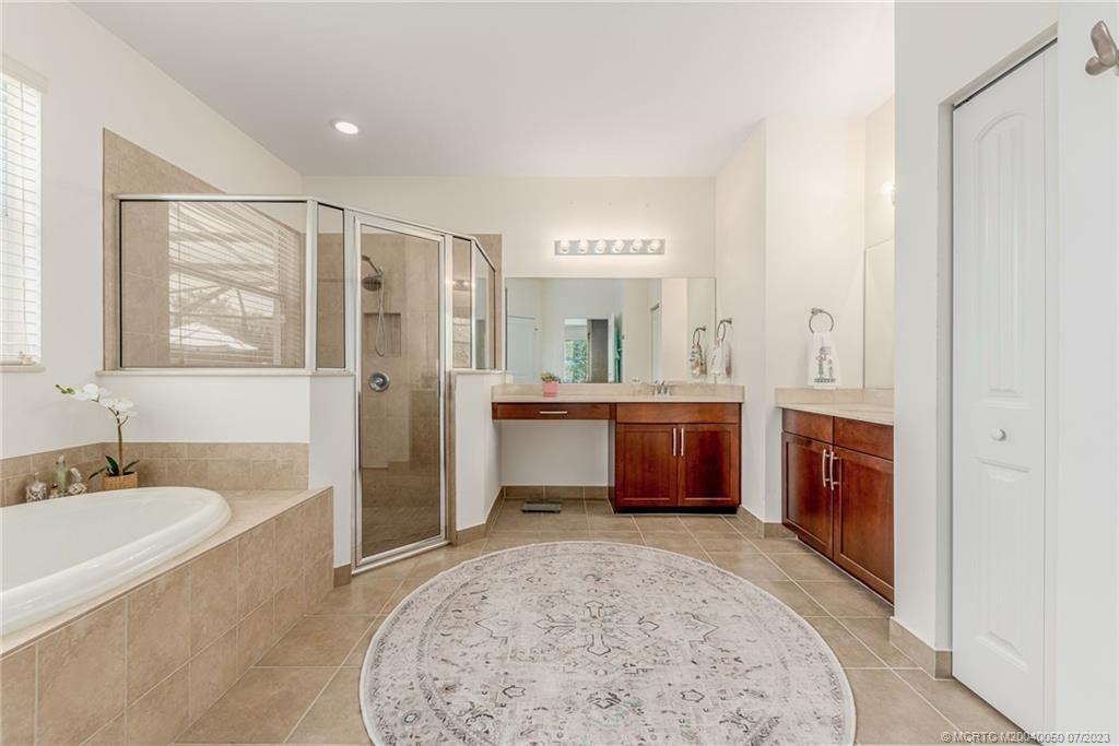 2185 Northwest Dalea Way Stuart, FL 34994 - Photo 20 of 55 a spacious bathroom with a tub a sink and a mirror