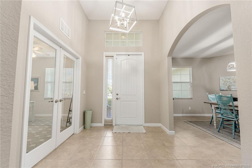 2185 Northwest Dalea Way Stuart, FL 34994 - Photo 7 of 55 a view of a hallway with dining area and glass door