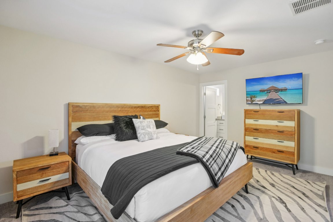 1206 Deloney Street, Unit B Austin, TX 78721 - Photo 22 of 39 Bedroom featuring light colored carpet, connected bathroom, and ceiling fan