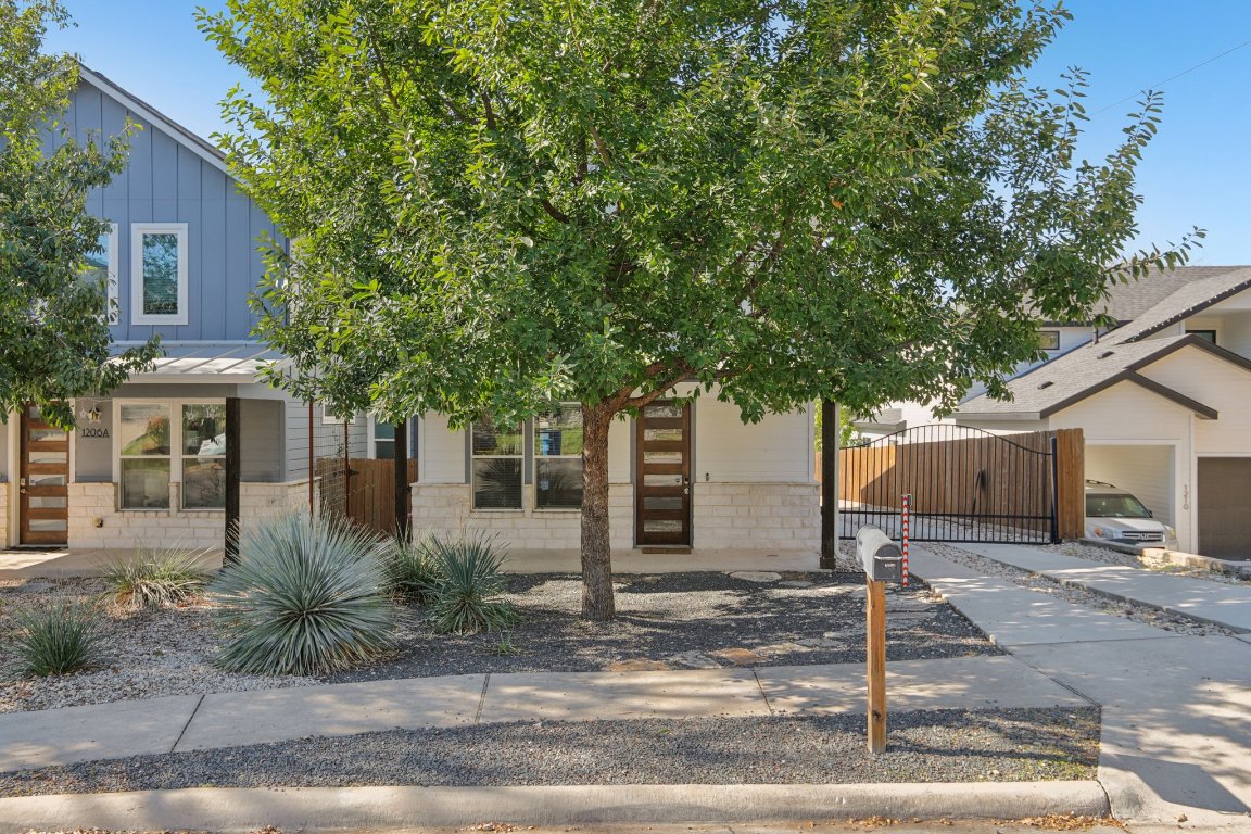 1206 Deloney Street, Unit B Austin, TX 78721 - Photo 37 of 39 View of property hidden behind natural elements featuring a gate and board and batten siding