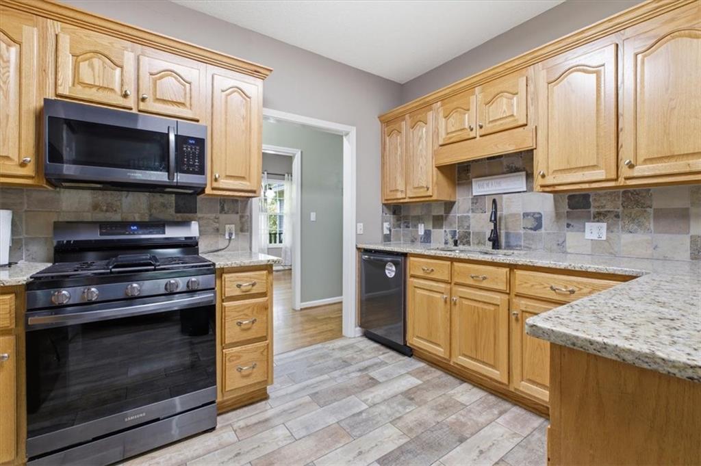 164 Laurens Road Rockmart, GA 30153 - Photo 13 of 41 a kitchen with stainless steel appliances granite countertop a stove microwave and cabinets