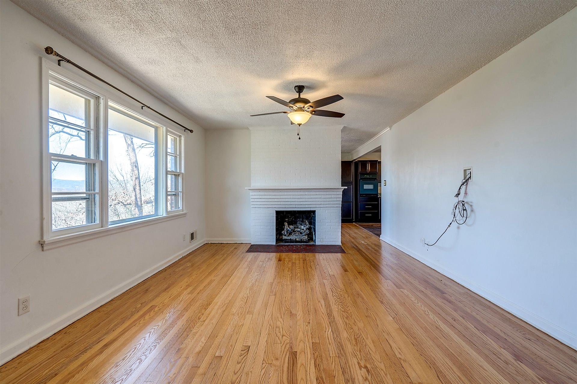 3026 Sedgefield Road Southwest Roanoke, VA 24018 - Photo 2 of 25 wooden floor fireplace and windows in an empty room