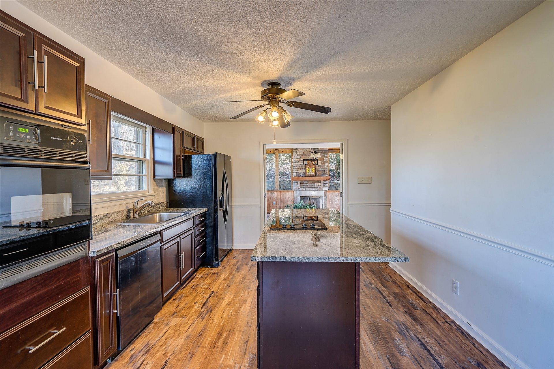 3026 Sedgefield Road Southwest Roanoke, VA 24018 - Photo 5 of 25 a kitchen with stainless steel appliances a stove refrigerator a sink and dishwasher with wooden floor