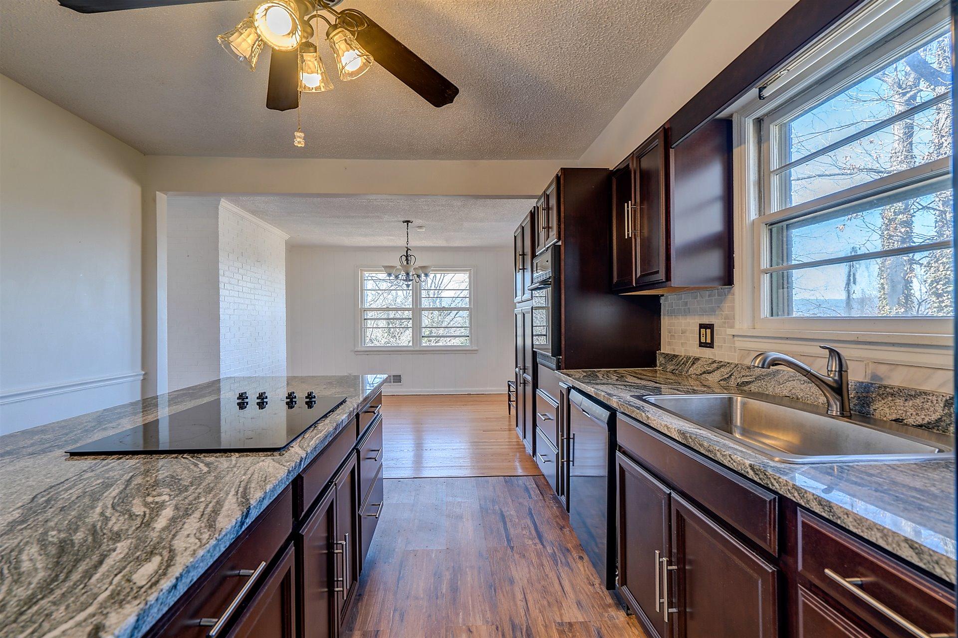 3026 Sedgefield Road Southwest Roanoke, VA 24018 - Photo 8 of 25 a kitchen with stainless steel appliances granite countertop a sink dishwasher stove and refrigerator with wooden floor