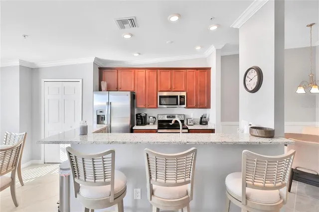 a kitchen with stainless steel appliances a dining table and chairs