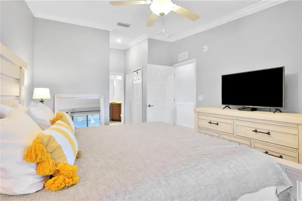 a bedroom with a bed tv and a chandelier