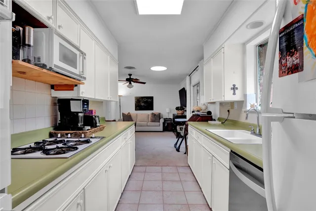 a kitchen with a stove a sink dishwasher and a refrigerator