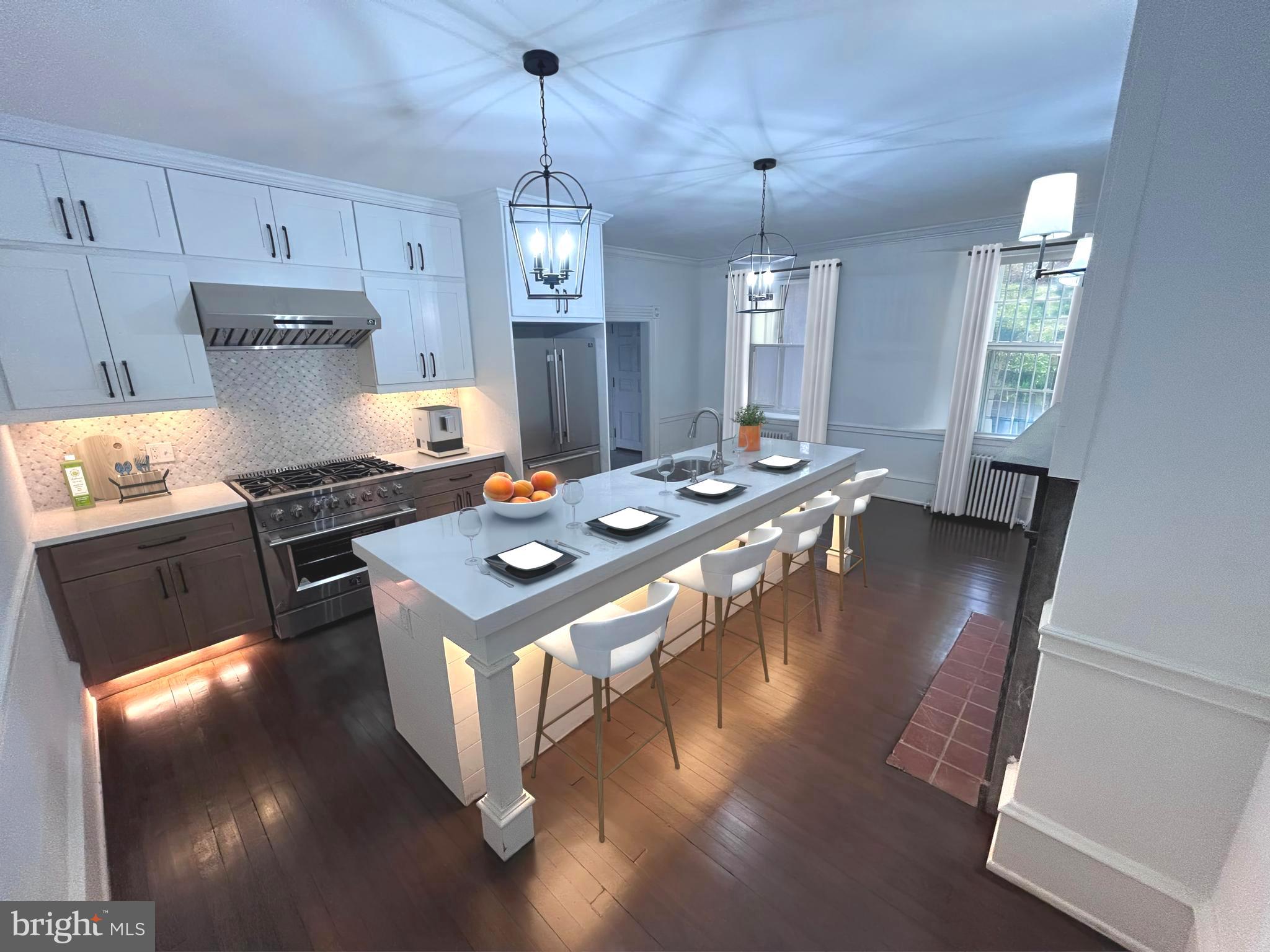 a kitchen with stainless steel appliances granite countertop a stove a refrigerator a kitchen island a stove and a sink