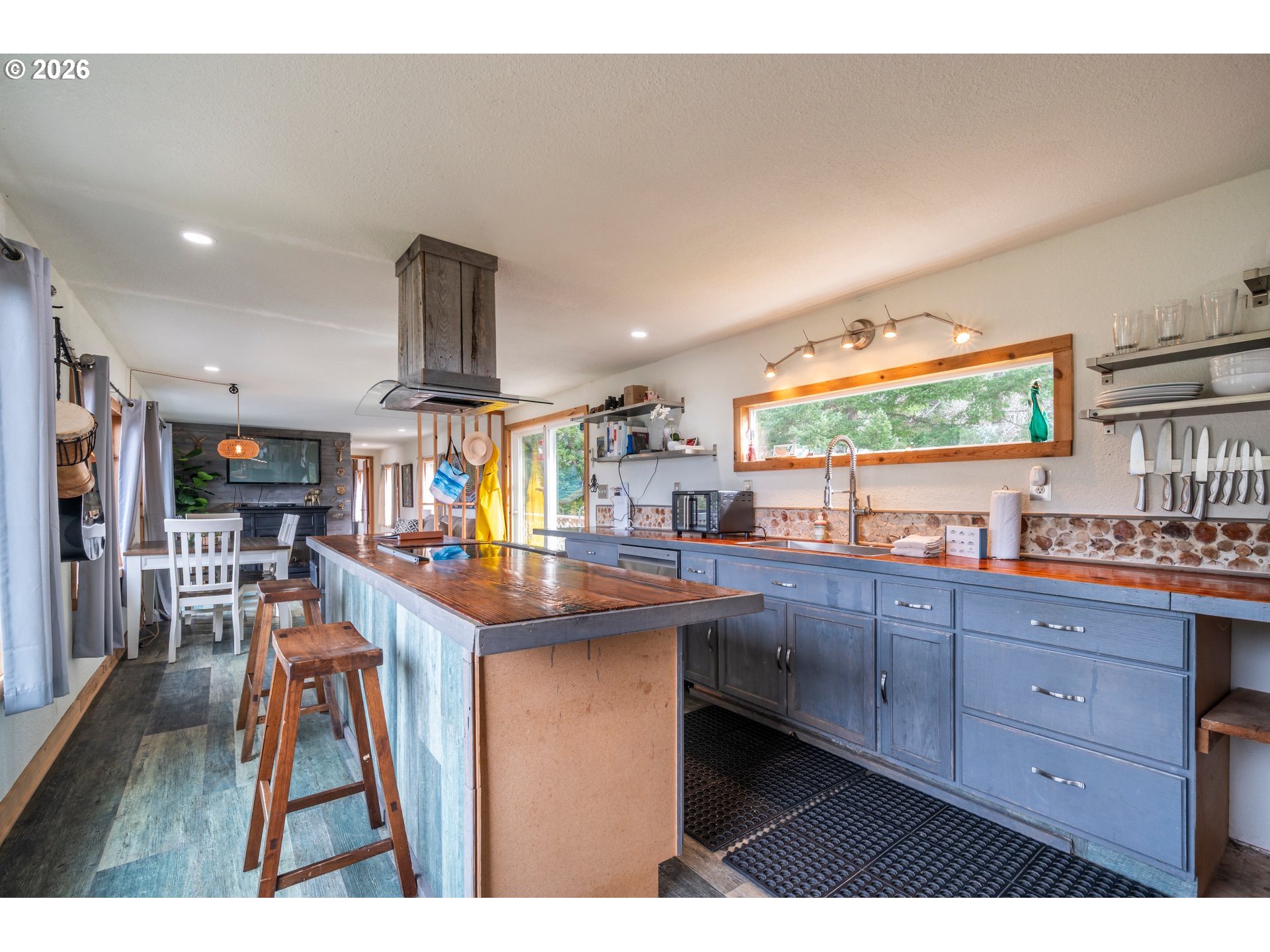 42365 Hensley Hill Road Port Orford, OR 97465 - Photo 18 of 47 a kitchen with stainless steel appliances kitchen island granite countertop a sink and wooden cabinets