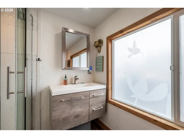 a bathroom with a sink mirror and a shower