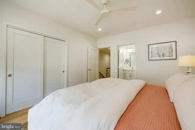 a spacious bedroom with a bed and a painting on the wall