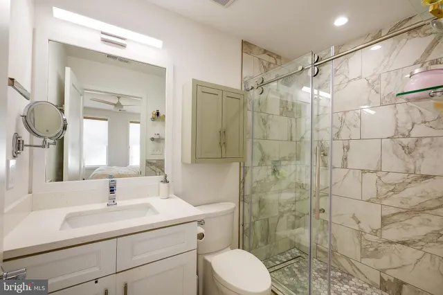 a bathroom with a sink toilet a mirror and shower