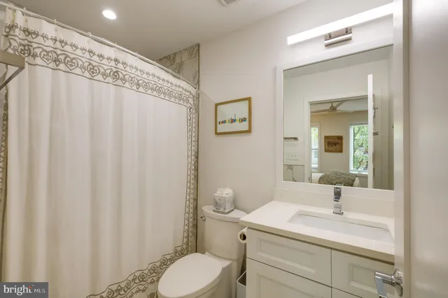 a bathroom with a sink a toilet and shower curtain