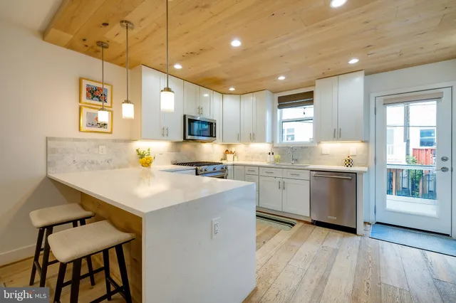 a kitchen with a sink cabinets and wooden floor