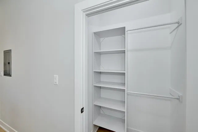 a view of walk in closet with empty racks