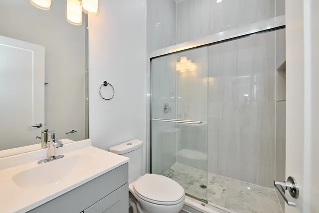 a bathroom with a sink a mirror toilet and shower