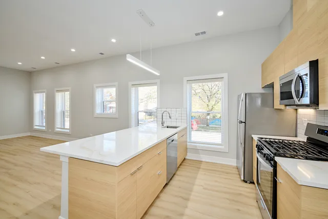 a large kitchen with kitchen island a sink stove and refrigerator