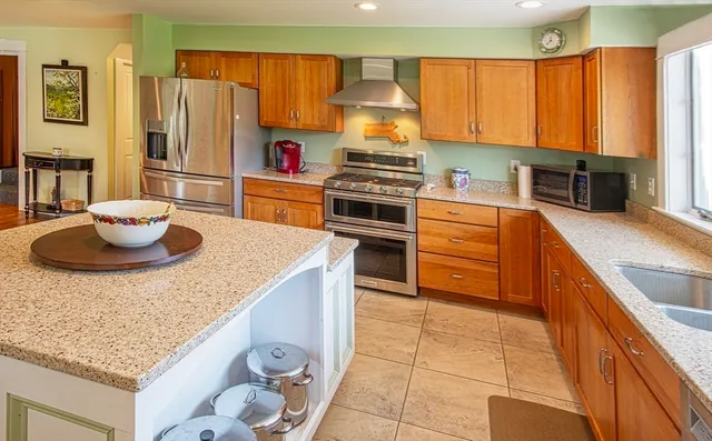 a kitchen with stainless steel appliances a stove a sink a microwave and wooden cabinets