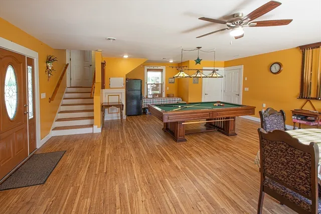 a living room with furniture floor to ceiling window and wooden floor