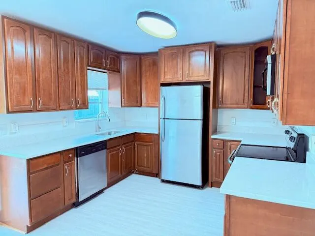 a kitchen with stainless steel appliances granite countertop a refrigerator and a sink
