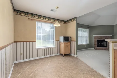 a view of empty room with a fireplace and windows