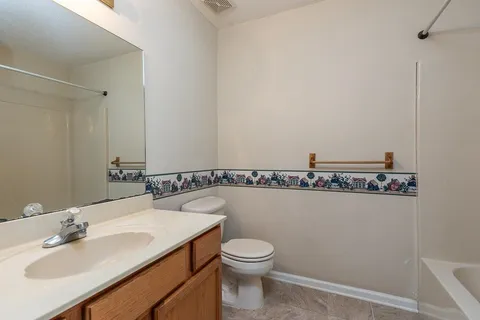 a bathroom with a sink mirror vanity and toilet