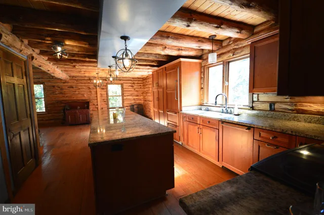 a kitchen with stainless steel appliances granite countertop a sink a stove and a wooden floors