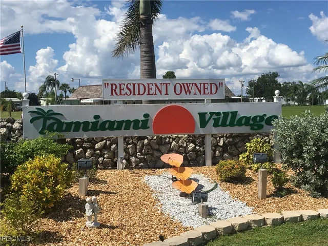 a sign that is sitting in front of flowers