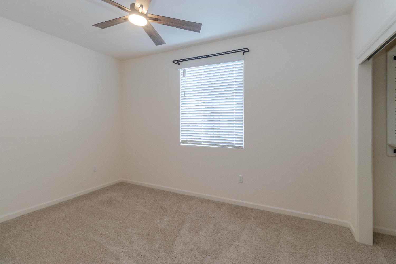 1158 Encore Way West Madera, CA 93636 - Photo 9 of 45 an empty room with a window and a fan