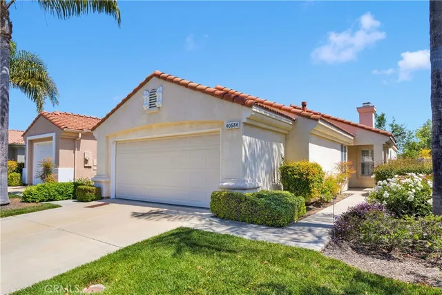 a front view of a house with a yard and potted plants