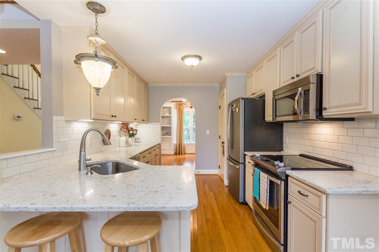 5321 Old Stage Road North Angier, NC 27501 - Photo 8 of 25 a kitchen with stainless steel appliances granite countertop a sink a stove and a wooden floor
