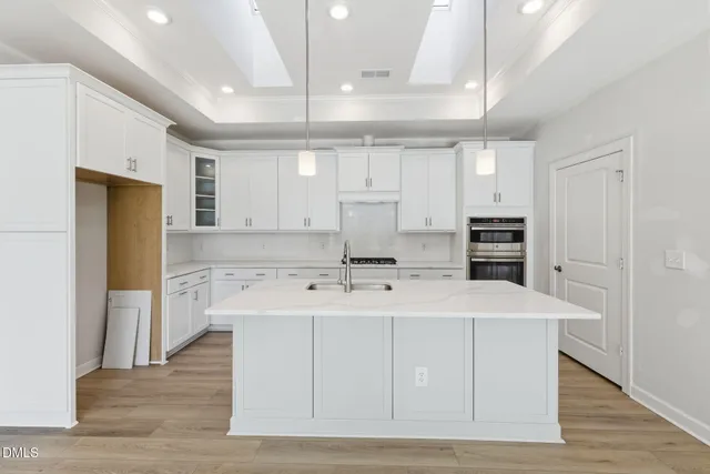 a large kitchen with kitchen island a sink stainless steel appliances and cabinets