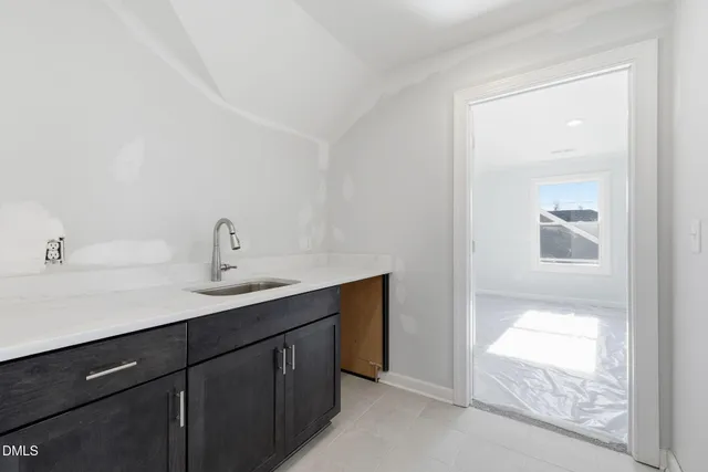 a bathroom with a sink a mirror and next to a window